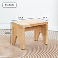 Solid wood distressed finish changing stool with bracket legs on a wooden floor.