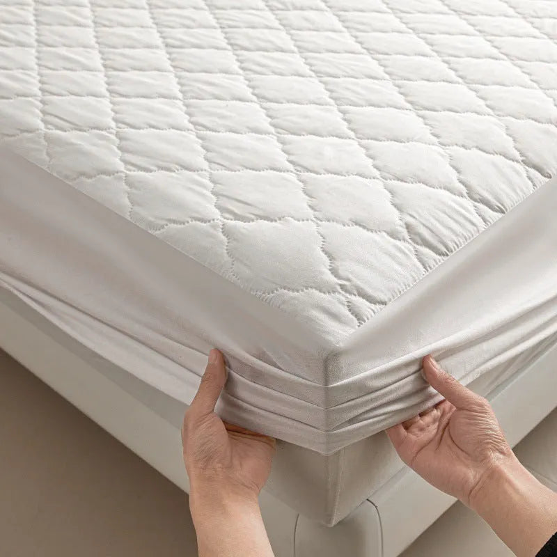 Diamond lattice quilted waterproof mattress protector in bamboo fibre, shown in a solid colour on a bed.