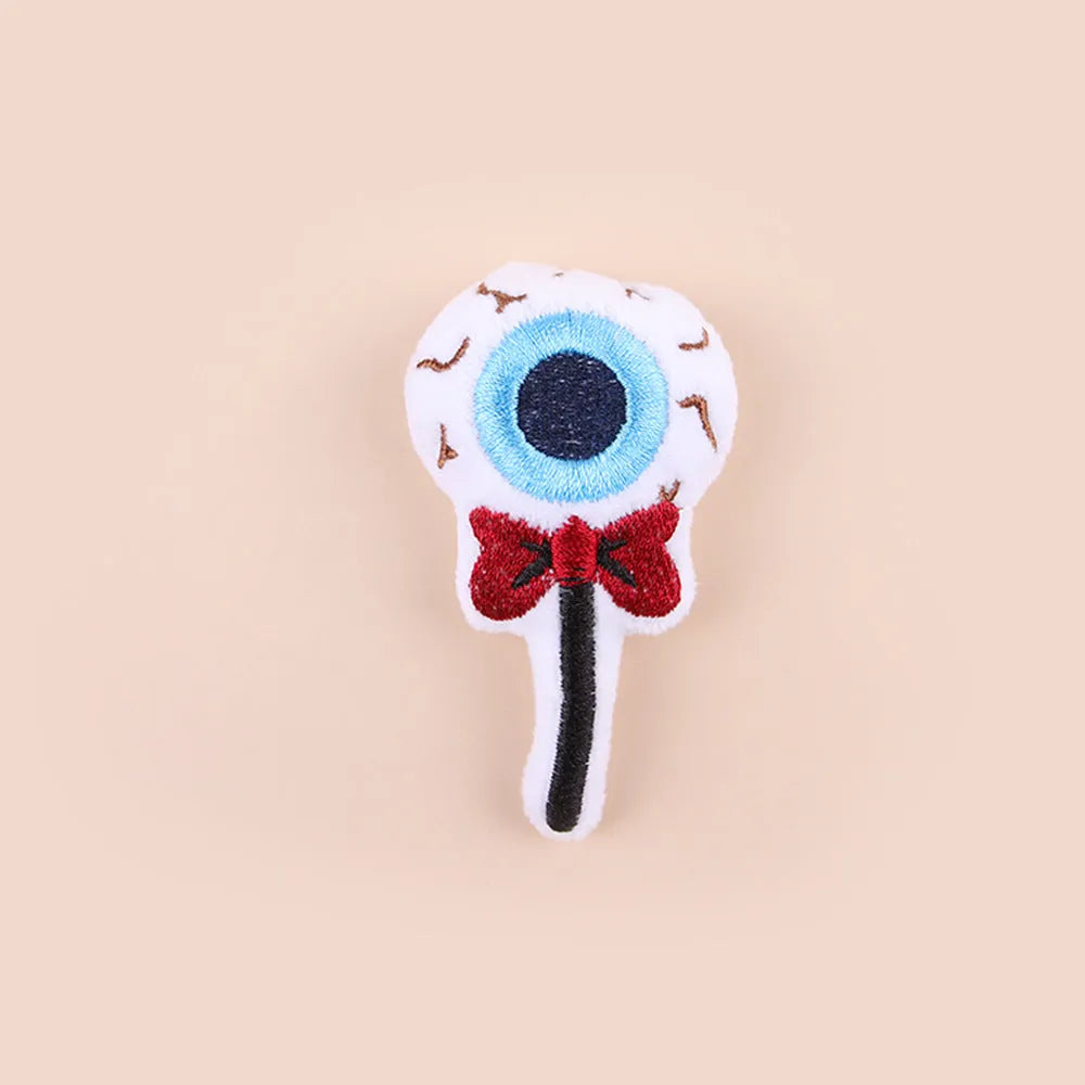 Plush cat teaser toy with long wand handle showing candy and skull designs