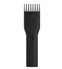 Black and white cordless hair clipper with adjustable comb and ceramic cutter head on a plain background