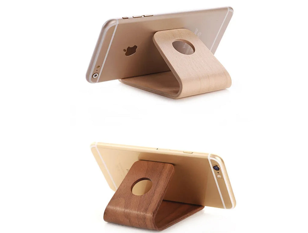Wooden stand for iPhone in Walnut finish, placed on a desk, holding a phone for hands-free viewing