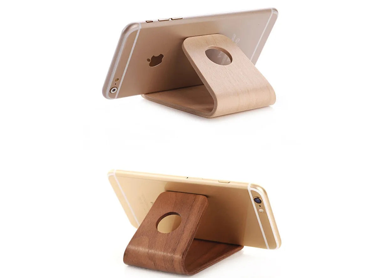 Wooden stand for iPhone in Walnut finish, placed on a desk, holding a phone for hands-free viewing