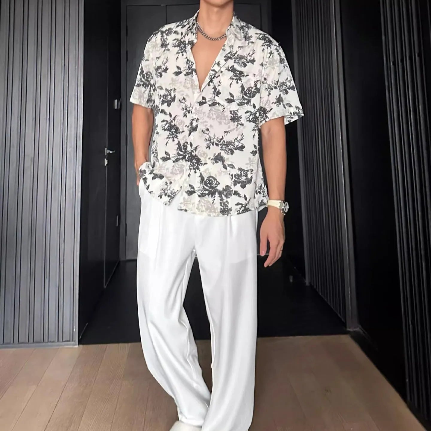 Loose black and white floral print short sleeve casual shirt on a hanger.