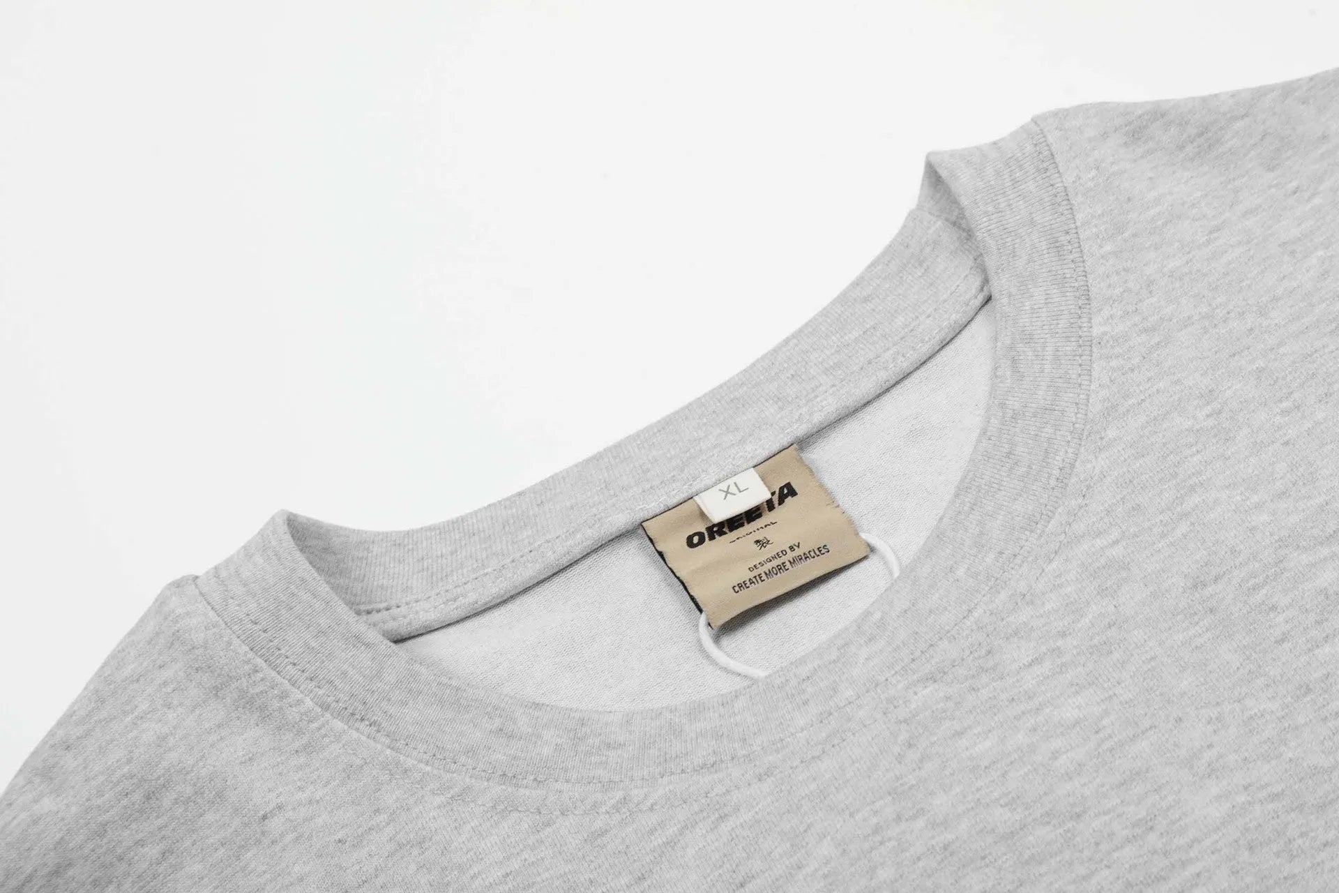A loose-fitting long sleeve cotton pullover in grey, shown on a model for casual wear.