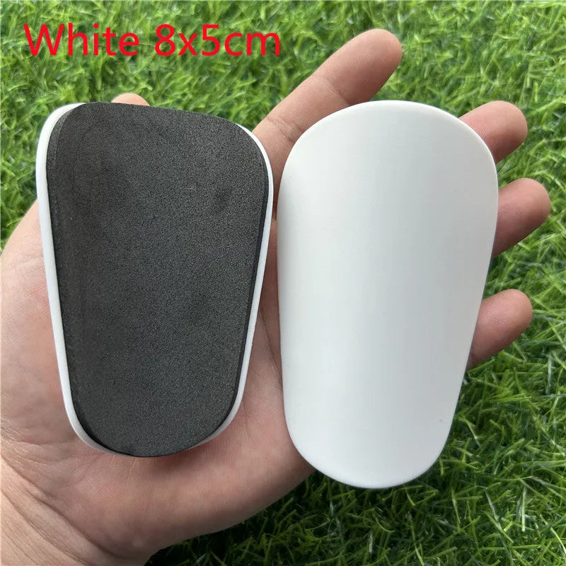 Extra small mini football shin guards measuring 8x5cm in black and white plastic