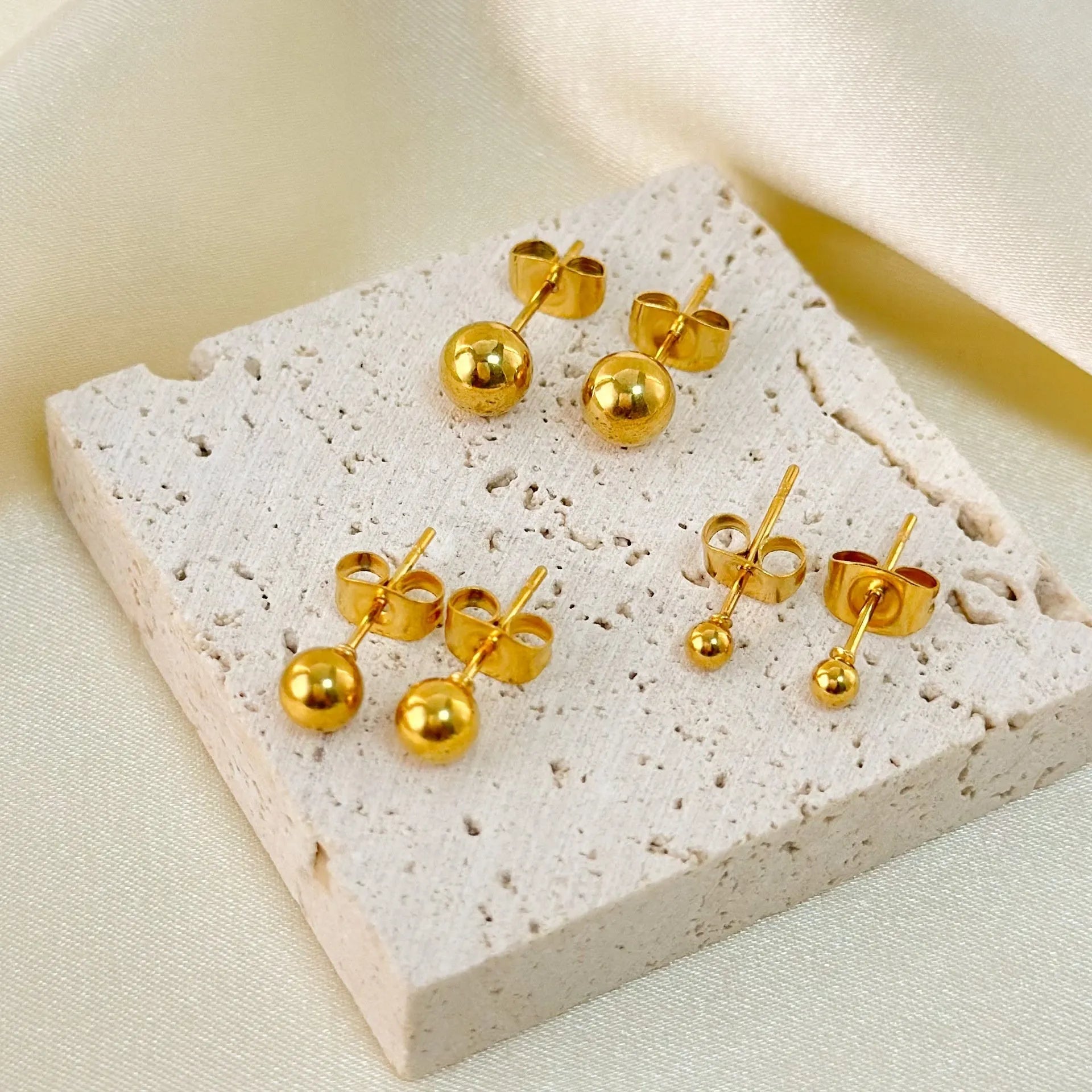 Stainless steel ball stud earrings in gold and silver finishes, showing 3mm, 4mm, 5mm and 6mm size comparison.