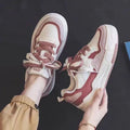 Pink and white low-top sneakers with rubber soles and imitation leather lining