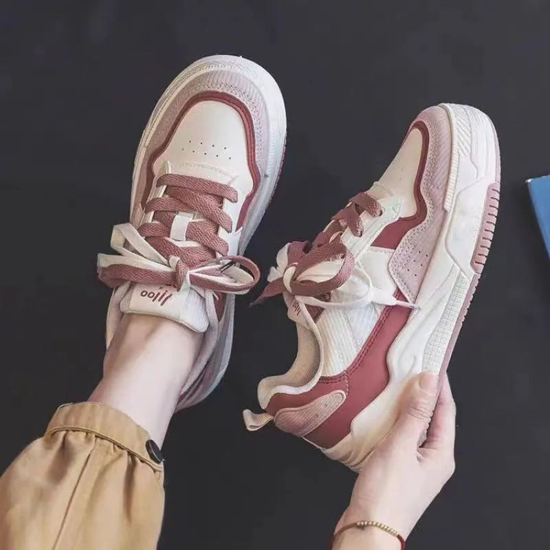 Pink and white low-top sneakers with rubber soles and imitation leather lining