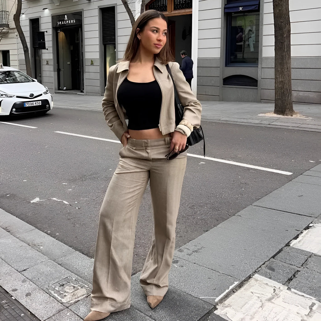 Women's grey herringbone pattern suit with long sleeve coat and straight-leg trousers, showing embroidery detail.