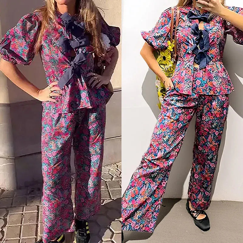 Women's floral print trouser suit with tie-neck blouse featuring puff sleeves