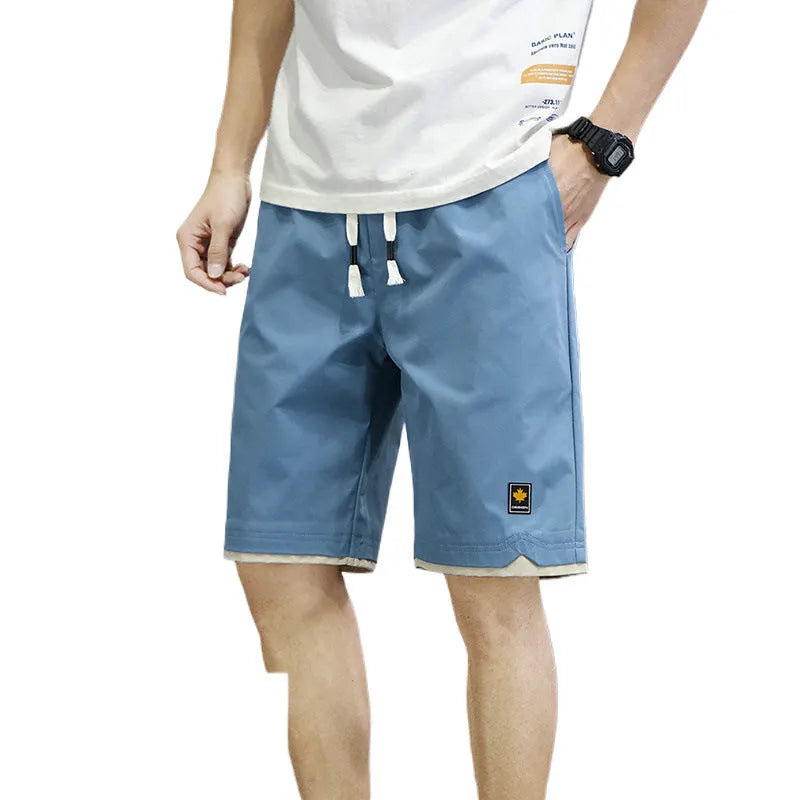 Man wearing green straight-leg loose fit casual beach shorts made from polyester.