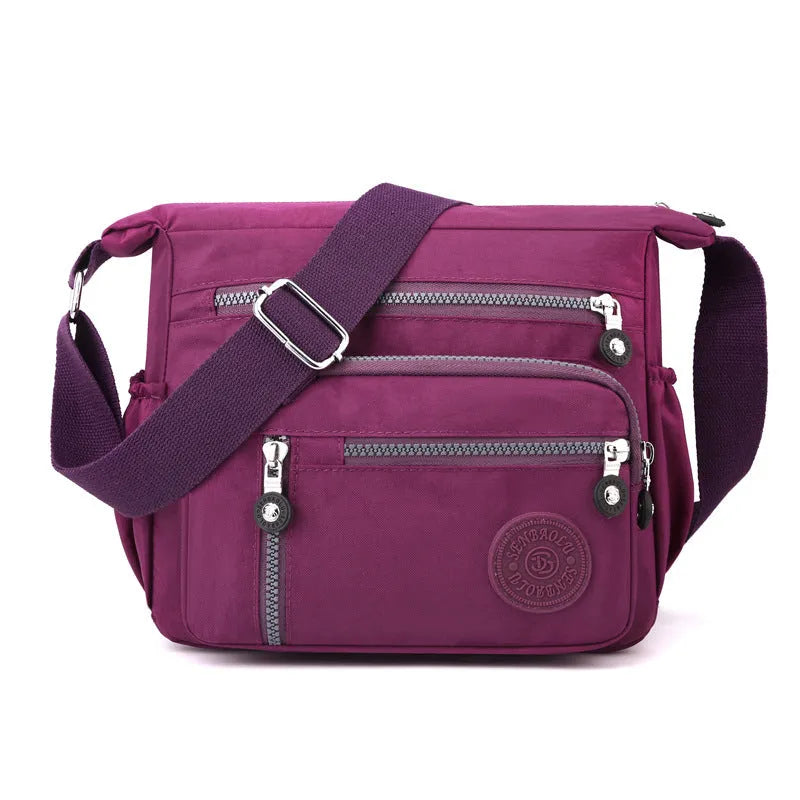 Soft nylon shoulder messenger bag in a square vertical shape with a single strap.