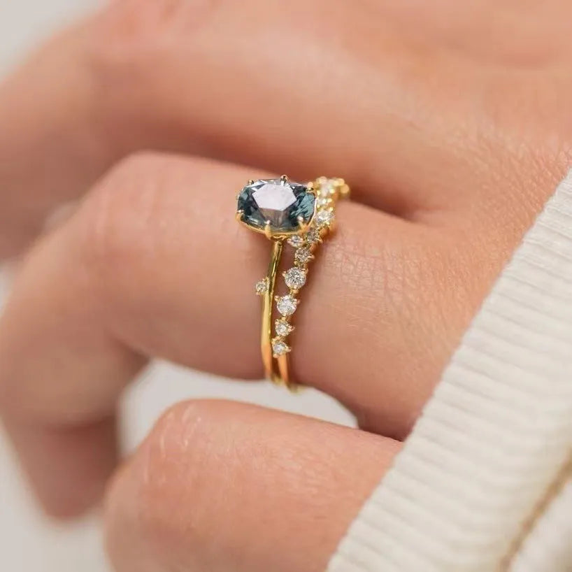 Gold plated alloy ring with floral design and green zircon stone, shown in various sizes