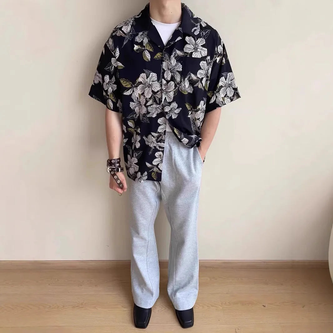 Men's black floral print ice silk Cuban collar short sleeve shirt laid flat.