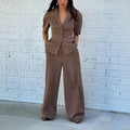 Brown men's slim fit two-piece polyester suit with long sleeves and regular trousers on a hanger.