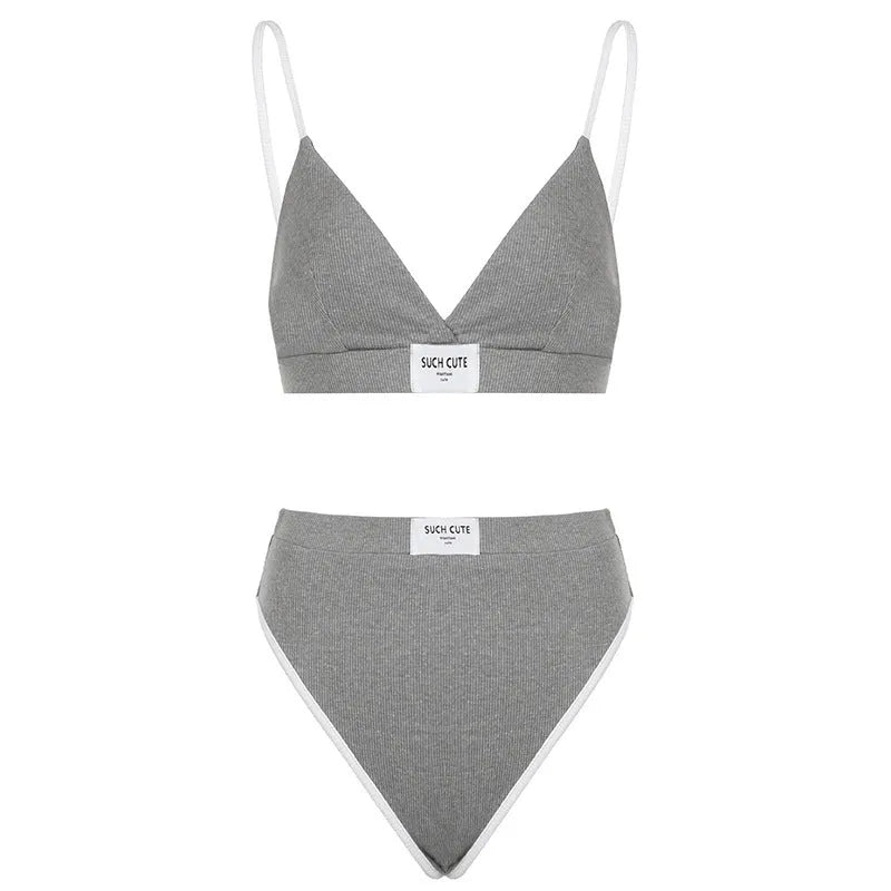 Women's black bikini set with white embroidered contrast binding letters on sleeveless top and shorts.