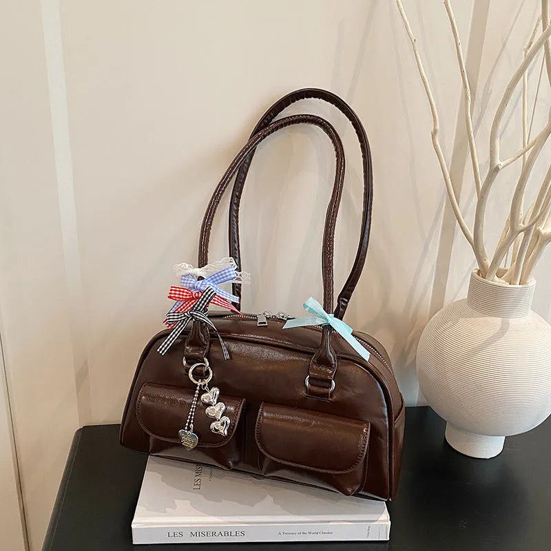 Retro brown PU leather women's pillow bag with double shoulder straps and a flap top closure.