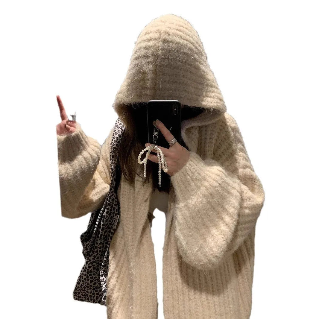 A woman wearing a thick, dark grey hooded cardigan with a loose fit and regular sleeves.