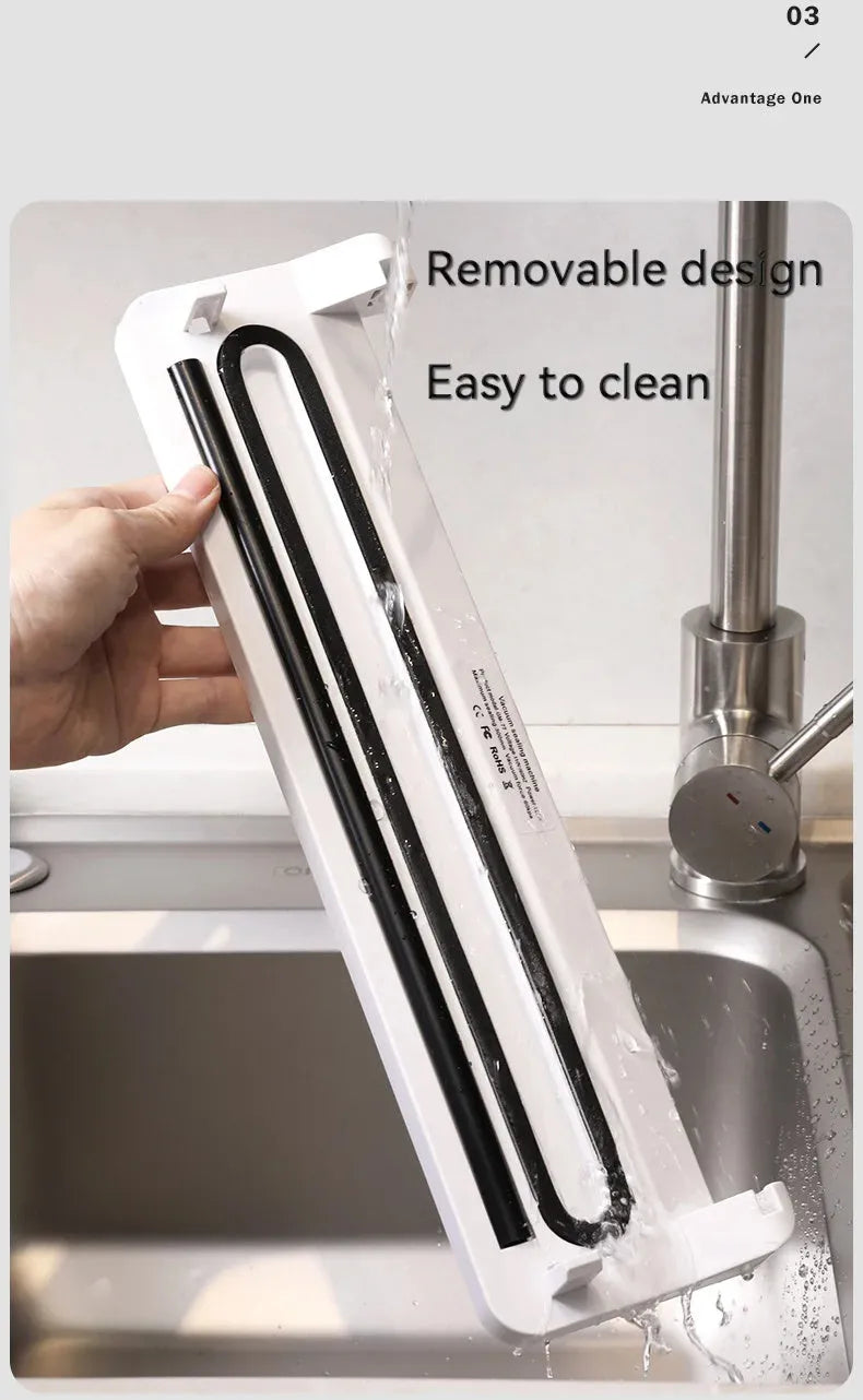White automatic household vacuum sealer machine on a kitchen countertop.
