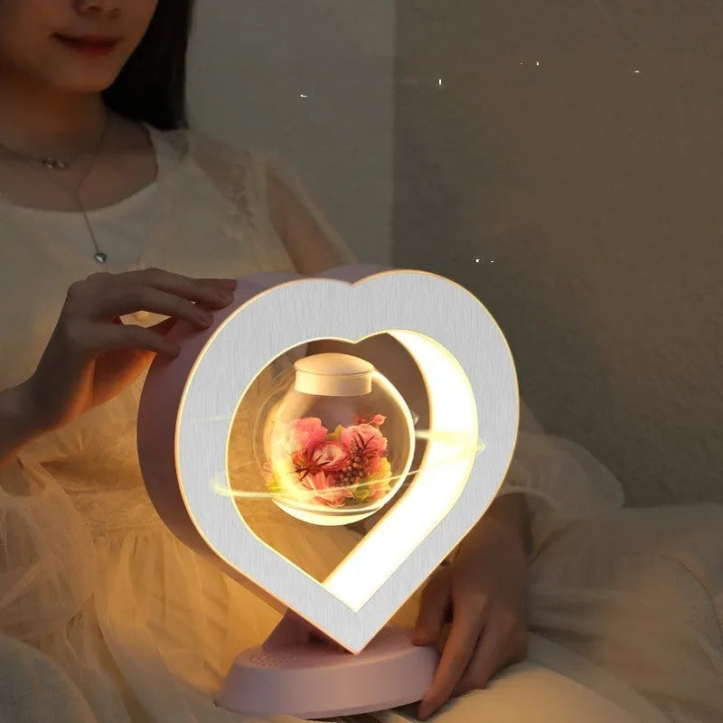 Magnetic levitation heart night light with pink eternal rose floating inside transparent sphere on triangular stand