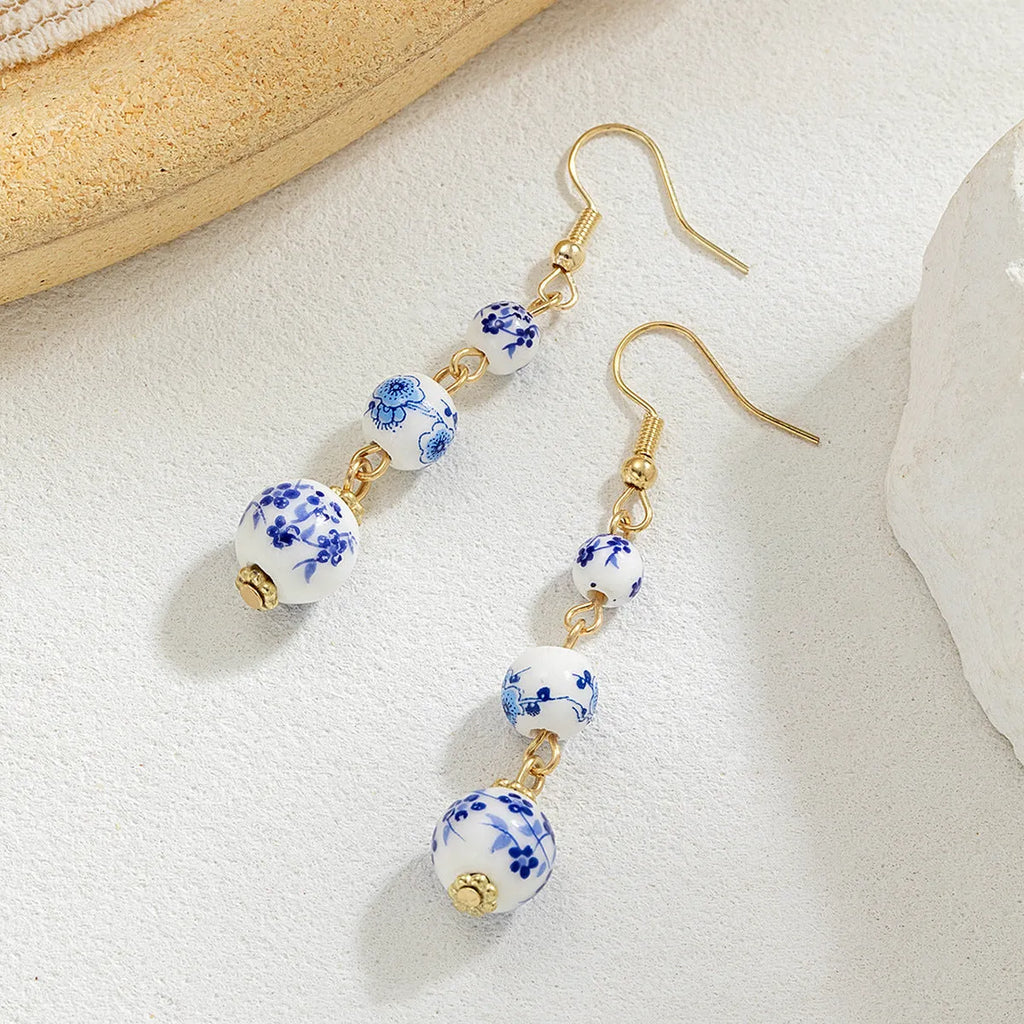 Blue and white porcelain ceramic beads long drop earrings on display with geometric round shape and alloy backing