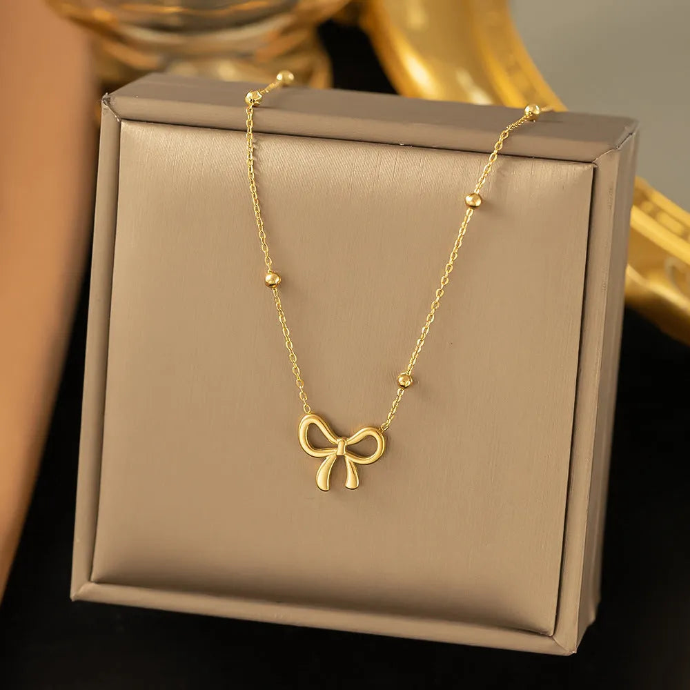 Gold electroplated bow pendant necklace on adjustable titanium steel chain