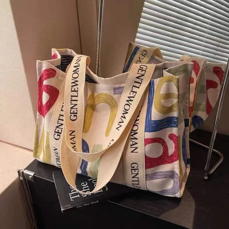 Large canvas shoulder tote bag with printed design, shown in available colour and pattern options.