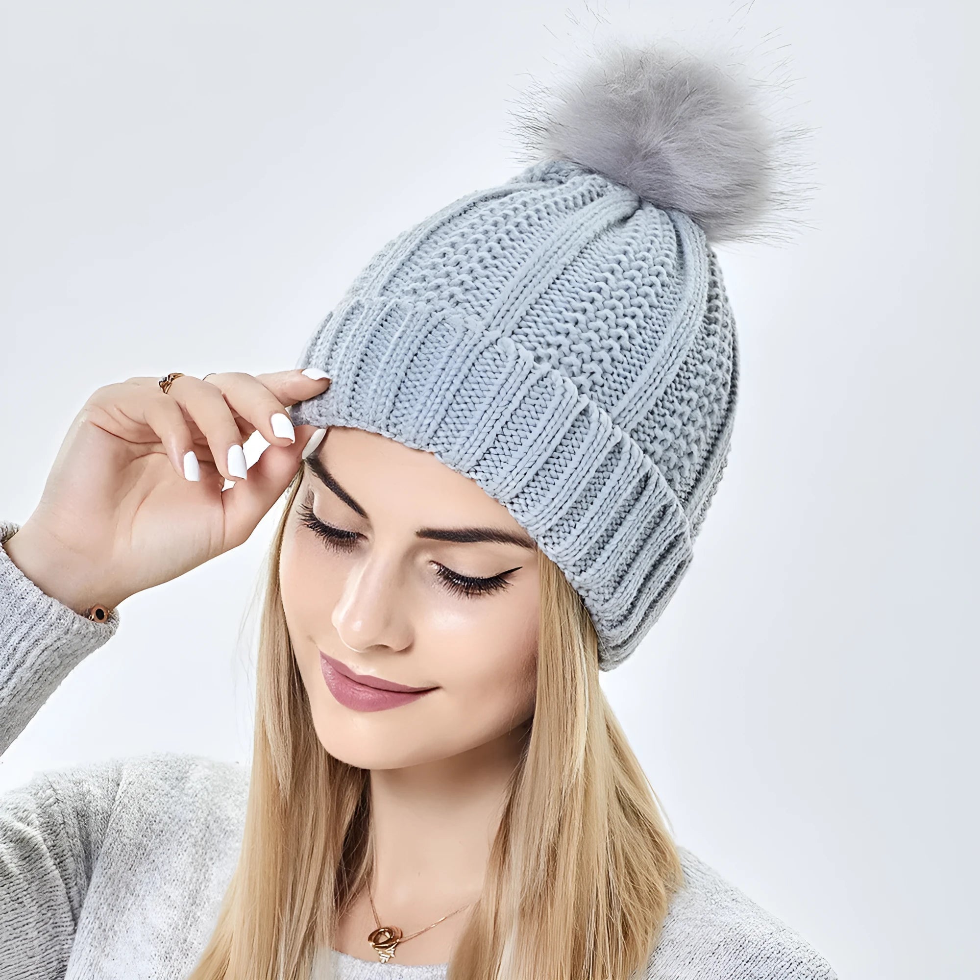 Women's wool knit beanie hat with faux fur pom pom and satin lining in eight colour options.