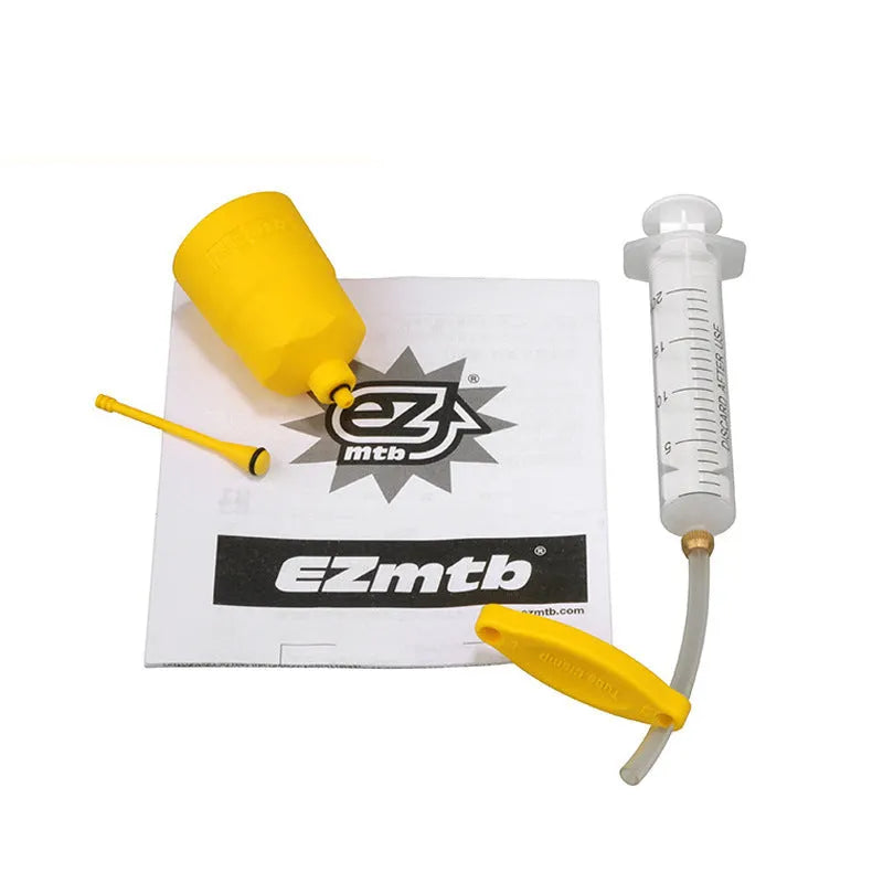 EZmtb bicycle hydraulic disc brake oil bleed kit tools with syringes, adapters, and wrenches on a workbench