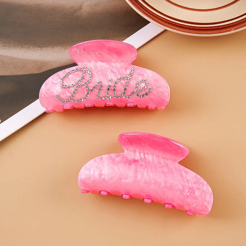 Acrylic hair barrette with diamond pattern and English letters measuring 10cm wide in pink colour