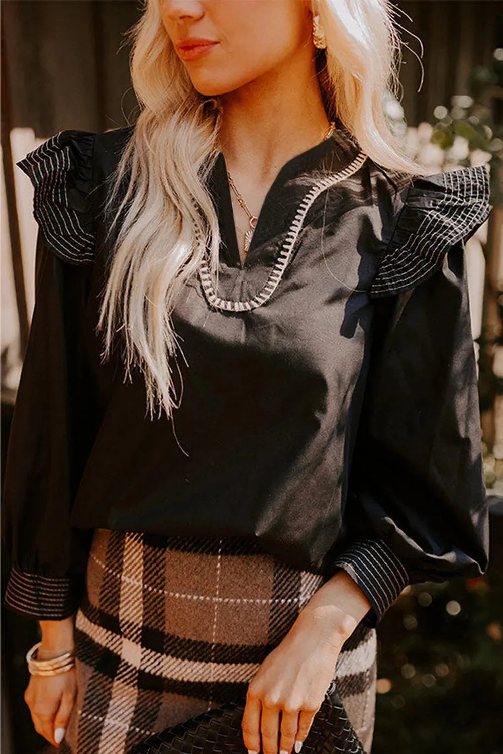 Black women's V-neck blouse with long ruffle sleeves and contrast stitching