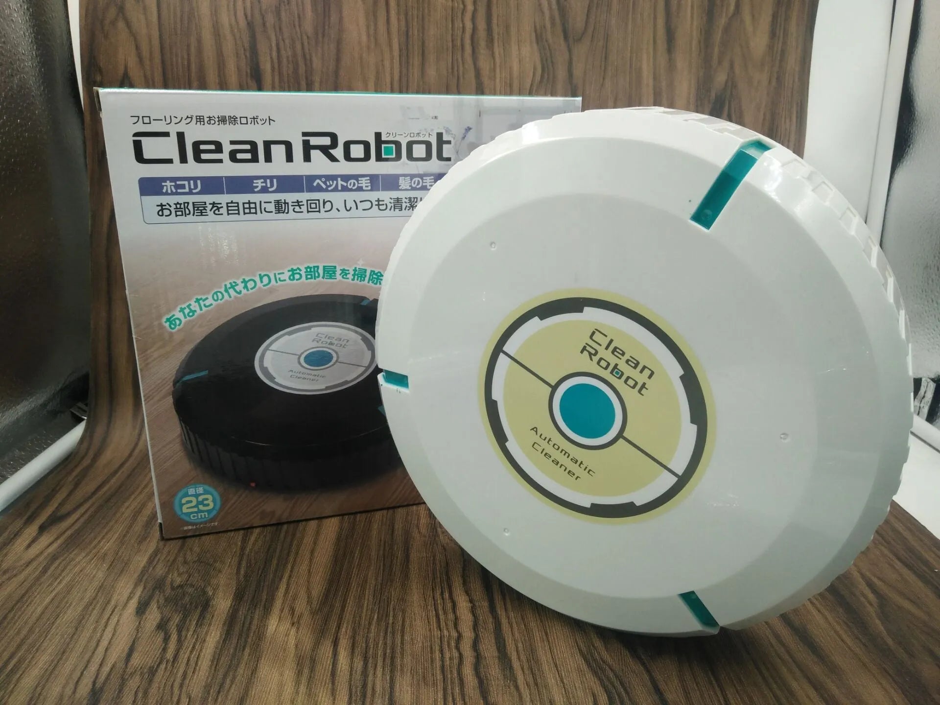 AC household automatic sweeping robot in black on a wooden floor.