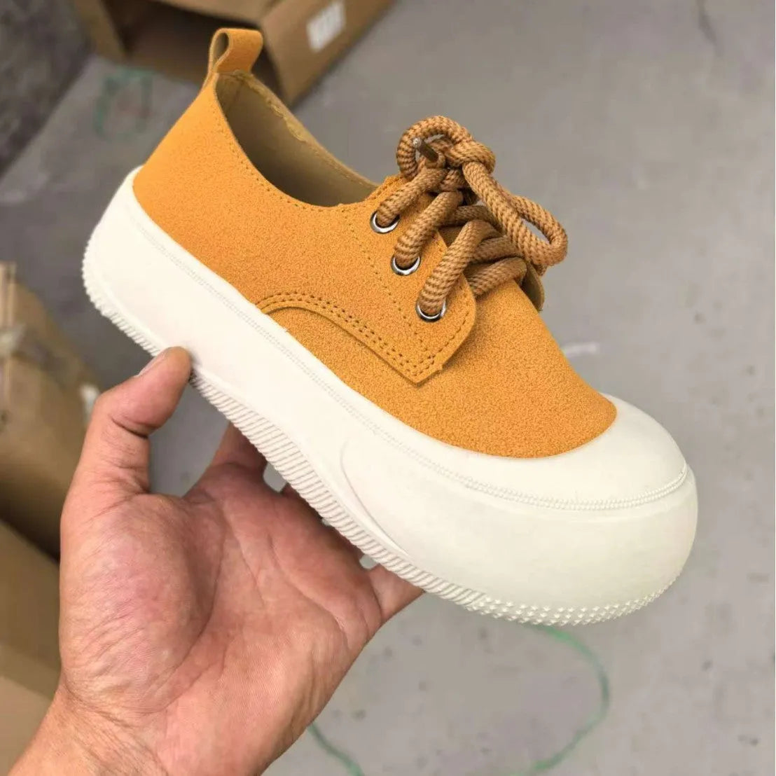 Women's camel suede platform loafers with round toe and front lace-up on a flat rubber sole.