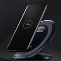 Black Qi wireless fast charging pad for Samsung Galaxy Note Edge on a desk next to a USB cable.