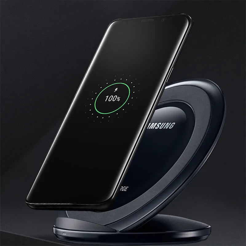 Black Qi wireless fast charging pad for Samsung Galaxy Note Edge on a desk next to a USB cable.