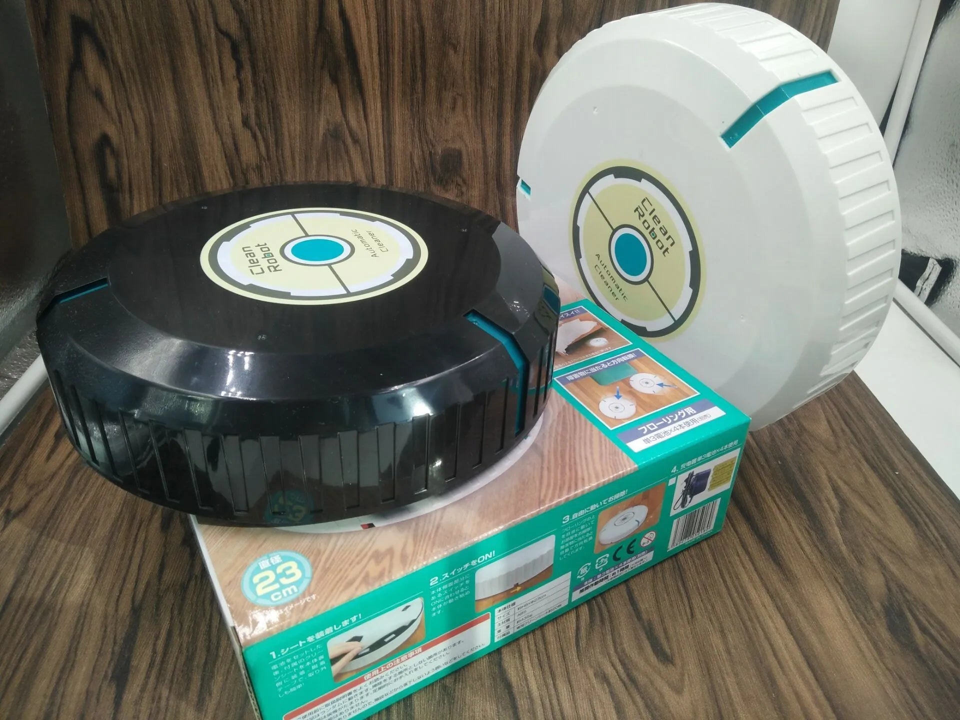 AC household automatic sweeping robot in black on a wooden floor.