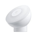 White modern bedside table lamp with human body induction and Bluetooth on a wooden nightstand.