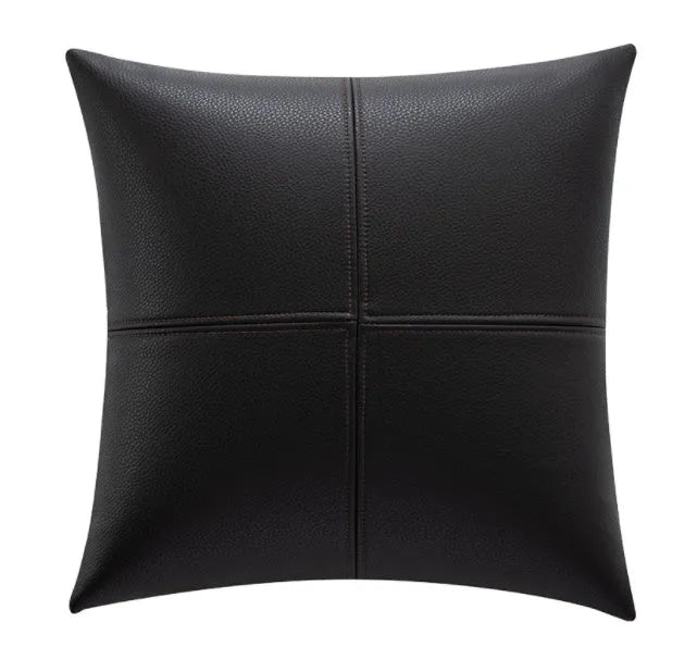 Solid colour cowhide leather pillow cover in brown on a grey sofa, shown in a square shape.