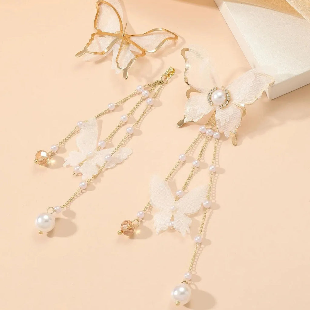 White butterfly earrings with lace pattern wings, pearl and rhinestone details, and dangling tassels