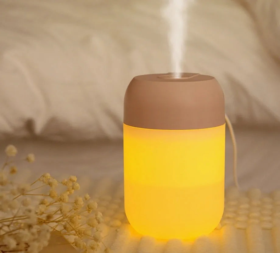 Small white cylindrical USB humidifier with charging cable on table