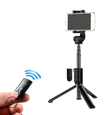 Black Bluetooth selfie stick tripod with remote control extended, holding a smartphone