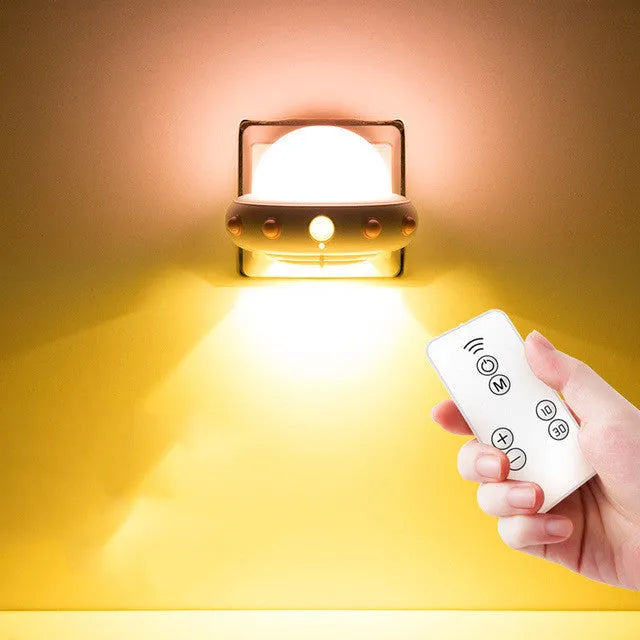 Remote control UFO-shaped bedside night light in blue, pink, or white colours.