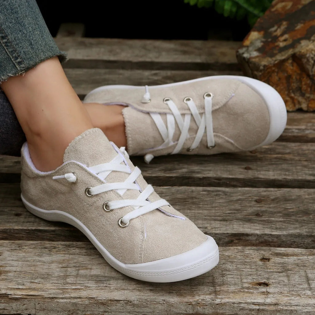 Women's creamy white casual low-top sneaker with soft fabric upper and rubber sole.
