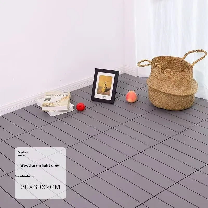 Plastic interlocking floor tiles in wood grain finish showing non-slip surface and edge connection.
