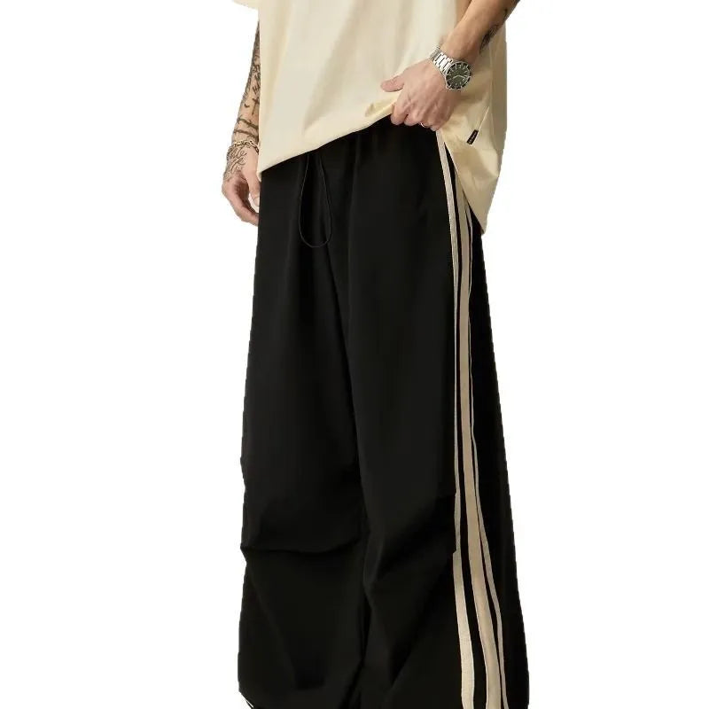 Black wide leg climbing trousers for men showing high waist and straight leg design on hanger.