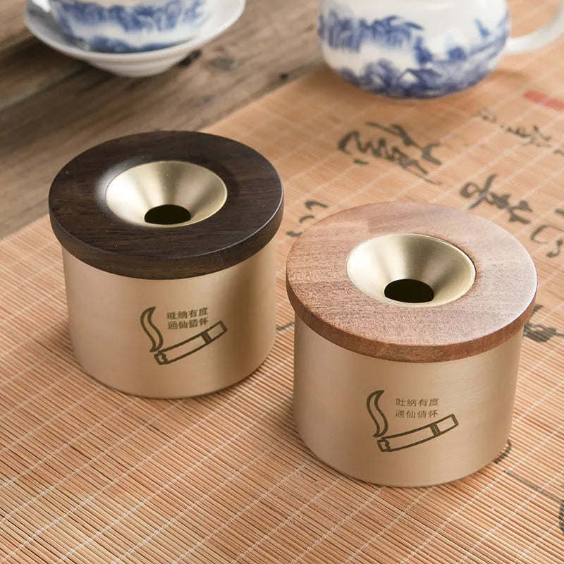 Retro brass and copper ashtray with wooden lid on a living room table.
