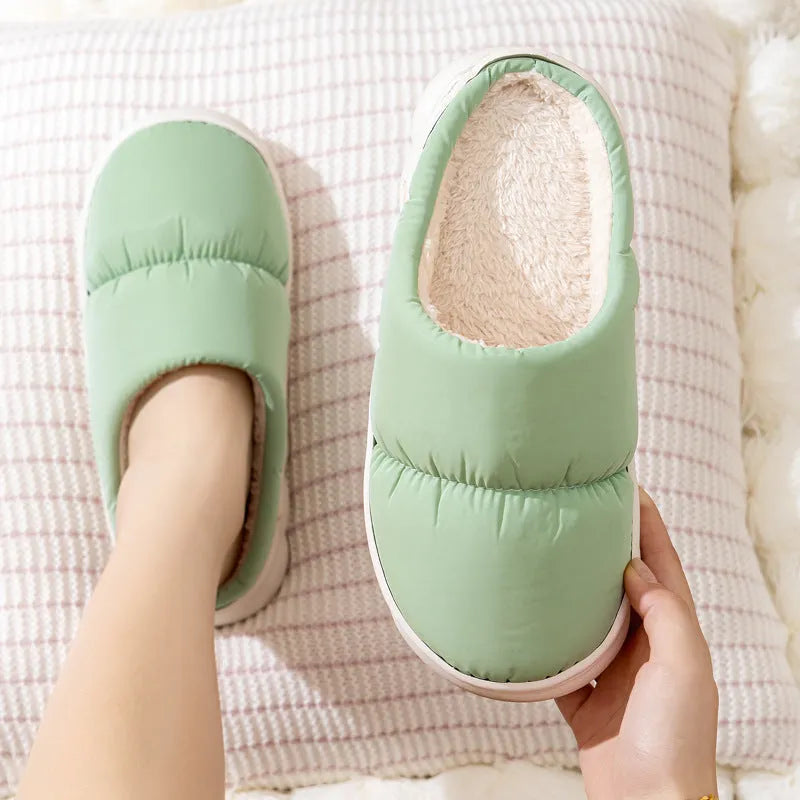 Blue winter house slippers with artificial leather upper, thick rubber sole, and plush lining on a wooden floor.