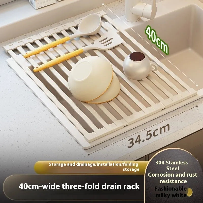Milky white tri-fold stainless steel kitchen draining rack shown unfolded next to a sink.