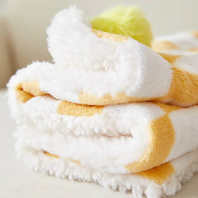 Plush pet blanket with plaid pattern and fur ball decoration for cats and dogs