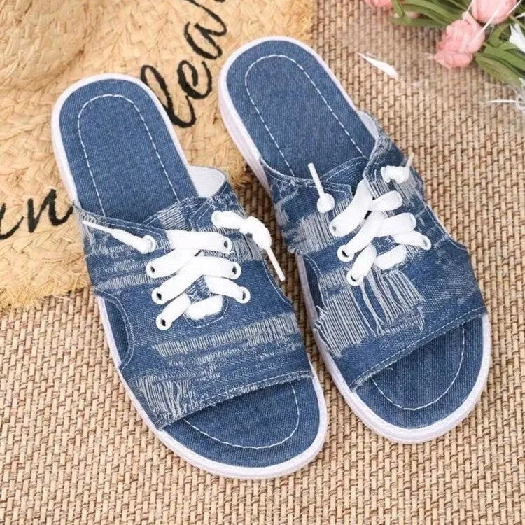 Blue women's Roman style canvas slippers with a flat rubber sole on a white background.